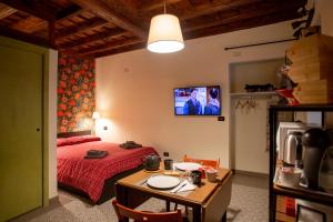 a bedroom with a bed and a table and a tv at Casa Vibrisse in Turin