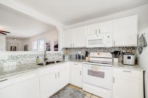 una cocina blanca con armarios y electrodomésticos blancos en Birchwood Getaway en San Antonio