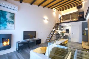 een woonkamer met een open haard en een trap bij Cuencaloft Buenavista in Cuenca