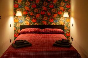 - une chambre avec un lit rouge et 2 serviettes dans l'établissement Casa Vibrisse, à Turin