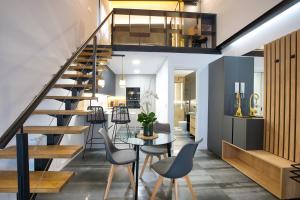 een trap in een woonkamer met een tafel en stoelen bij Cuencaloft Buenavista in Cuenca