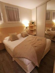 1 dormitorio con 1 cama grande y espejo en Best Western Grand Hotel de Bordeaux en Aurillac