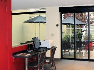 an office with a desk with a computer and an umbrella at New Hotel Saint Lazare in Paris