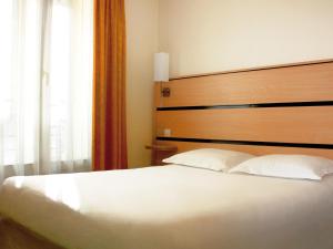 A bed or beds in a room at New Hotel Saint Lazare