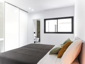 Un dormitorio con una cama grande y una ventana en Filomena Apartments LUXURY, en Mindelo