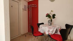 a table with chairs and a vase of flowers on it at Ferienwohnung-Ginkgo-A3 in Banjole
