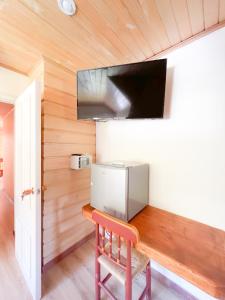 ein Esszimmer mit einem Holztisch und einem TV in der Unterkunft Agua y Campo Hotel Boutique in Osorno