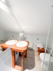 a bathroom with two sinks and a toilet at Agua y Campo Hotel Boutique in Osorno