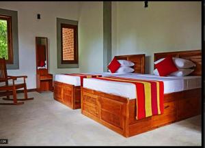 a bedroom with two beds and a chair in it at THE HIDEOUT KURUNEGALA in Kurunegala