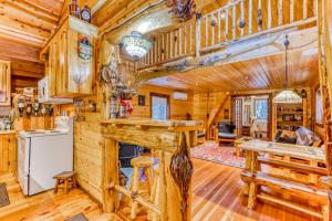 a log cabin kitchen with a fireplace and wooden floors at Cedar Cabin in Welches