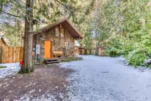 a log cabin in the woods with snow on the ground at Cedar Cabin in Welches