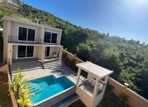 a house with a swimming pool in front of a hill at The Indianna ~ Luxury Pool & Spa in Whitehouse
