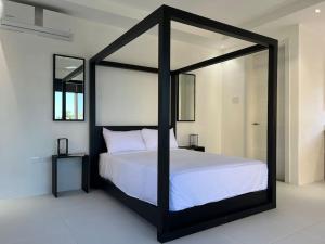 The Indianna ~ Luxury Pool & Spa في Whitehouse: غرفة نوم مع سرير من المظلة السوداء والبيضاء