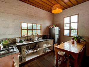 a kitchen with a table and a refrigerator at Hostal Tralala Salento in Salento