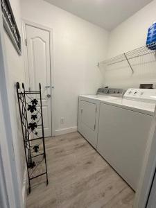 a white kitchen with a stove and a dishwasher at Private Finca on 2 Acres with Pool in Naples