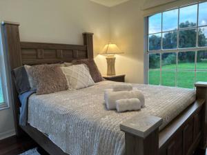 a bedroom with a large bed with two towels on it at Private Finca on 2 Acres with Pool in Naples +47 photos