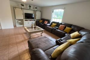 a living room with a leather couch and a table at Private Finca on 2 Acres with Pool in Naples