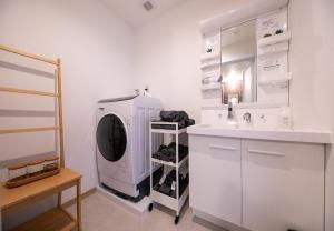 a white bathroom with a sink and a washing machine at Hotel Best Price Kochi - Vacation STAY 17530v in Kochi