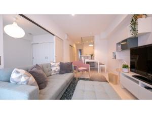 a living room with a couch and a tv in a room at Hotel Best Price Kochi - Vacation STAY 17532v in Kochi