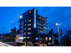 a tall blue building with lights on it at night at Hotel Best Price Kochi - Vacation STAY 17542v in Kochi