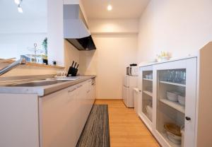 a kitchen with white cabinets and a sink at Hotel Best Price Kochi - Vacation STAY 17542v in Kochi