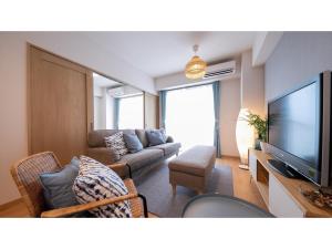 a living room with a couch and a flat screen tv at Hotel Best Price Kochi - Vacation STAY 17539v in Kochi