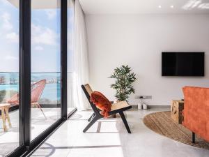 a living room with sliding glass doors and a tv at Filomena Apartments BOHÈME in Mindelo