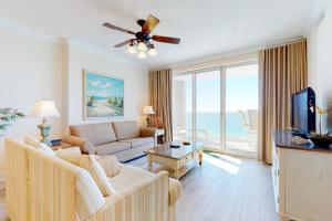 a living room with a couch and a tv at Ocean Villa 1706 in Panama City Beach