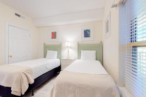 巴拿马城海滩Ocean Villa 1706的一间带窗户的白色房间里有两张床 更多14张照片