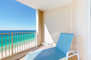 une chaise bleue sur un balcon avec vue sur l'océan dans l'établissement Ocean Villa 1706, à Panama City Beach