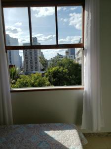 a bedroom window with a view of a city at Espaço Inteiro para 08 pessoas próximo a área hospitalar em BH in Belo Horizonte
