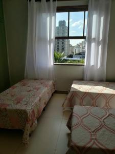 1 dormitorio con 2 camas y ventana con vistas en Espaço Inteiro para 08 pessoas próximo a área hospitalar em BH, en Belo Horizonte