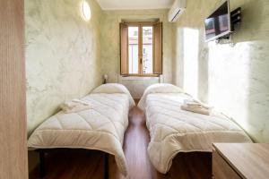 3 camas en una habitación con ventana en B&B Sasso, en Cosenza