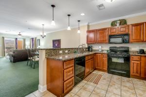 a kitchen with wooden cabinets and a living room at Bon Air Unit 4032 in Gatlinburg