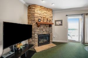 a living room with a stone fireplace with a flat screen tv at Bon Air 2011 in Gatlinburg