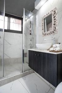 een badkamer met een douche, een wastafel en een spiegel bij Lovely 2 bedroom unit, Shivtey Israel, Jerusalem in Jeruzalem