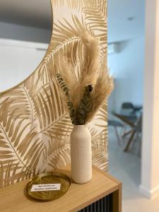 un vase avec des plumes assise sur une table dans l'établissement Garden Hill Apartment, à Albufeira