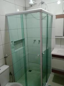 a glass shower in a bathroom with a toilet at AP 22 hortência in Poços de Caldas