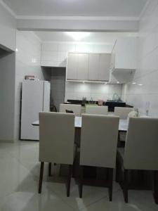 a kitchen with a table and chairs and a refrigerator at AP 22 hortência in Poços de Caldas +8 photos
