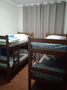 two bunk beds in a room with a window at AP 22 hortência in Poços de Caldas