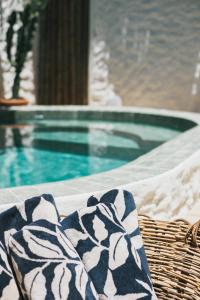 una sedia in vimini con coperta accanto alla piscina di Pousada Villa Cacau a Trancoso