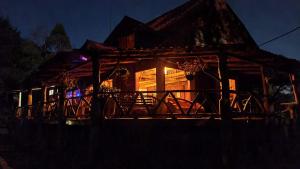 ein Haus in der Nacht mit eingeschaltetem Licht in der Unterkunft Reserva y Estancia Robles Mimosos Lodge in Cartago