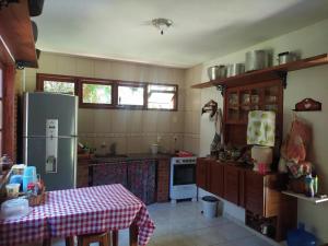 uma cozinha com uma mesa e um frigorífico em Sítio Recanto Amado. em Santa Teresa
