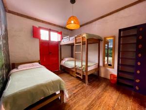 a room with two bunk beds and a mirror at Hostal Tralala Salento in Salento