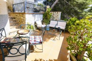 a patio with chairs and a glass table on a patio at Buda Villa Planetcostadorada in Salou +43 photos