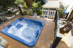 un bain à remous bleu sur une terrasse avec une clôture dans l'établissement Buda Villa Planetcostadorada, à Salou