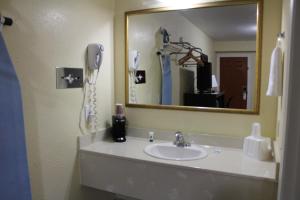 a bathroom with a sink and a mirror at Rodeway Inn Medford South I-5 in Medford +64 photos