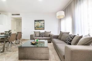 ein Wohnzimmer mit einem Sofa und einem Tisch in der Unterkunft Luxury 3 bedroom apt, Harav Kook7 in Jerusalem