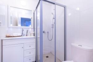 biała łazienka z prysznicem i umywalką w obiekcie Luxury 3 bedroom apt, Harav Kook7 w Jerozolimie