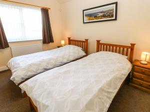 two twin beds in a bedroom with a window at Coquet in Longframlington